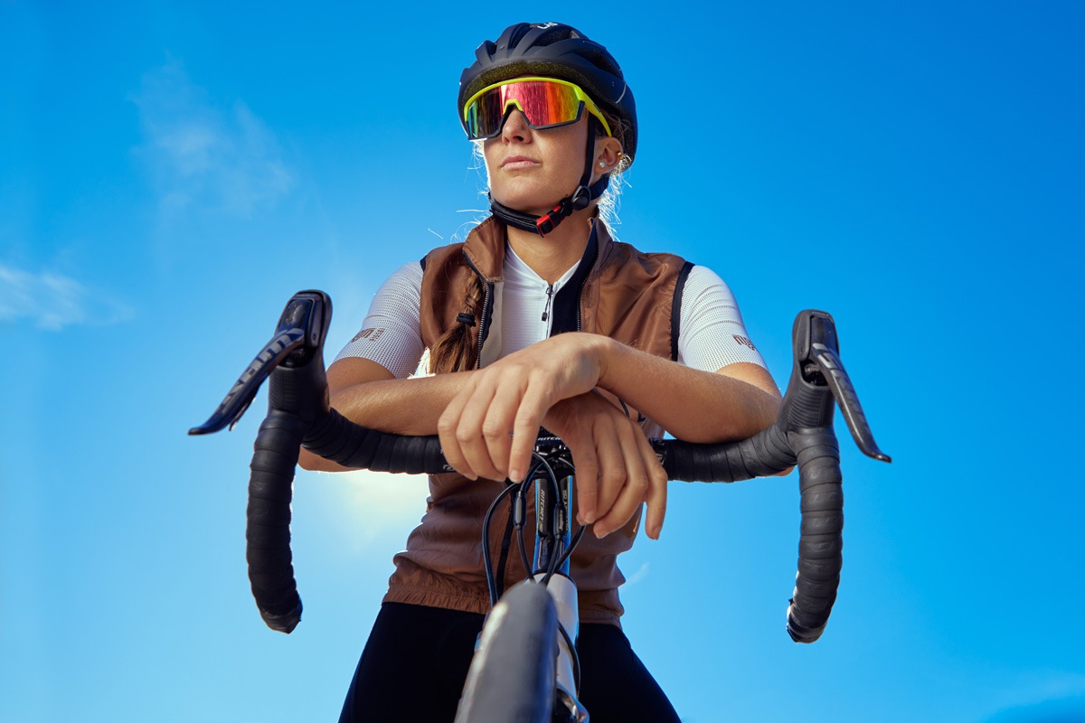 Foto di una ragazza in bici con occhiali sportivi. Set fotografico per gestione social